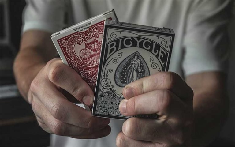 guy holding two decks of cards